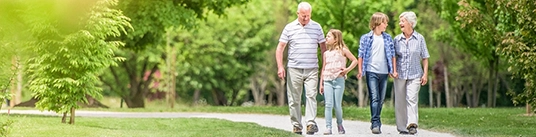 Un couple de grands-parents se promenant avec leurs petits-enfants