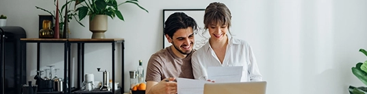 Couple souriant, assis devant un ordinateur